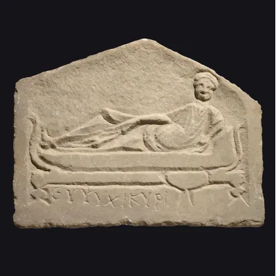 Avers, pour Romain — Funerary stele depicting a symposium with Greek inscription ‘Cheer up, Kyris’ — 3e siècle ap. J.-C., 3e...